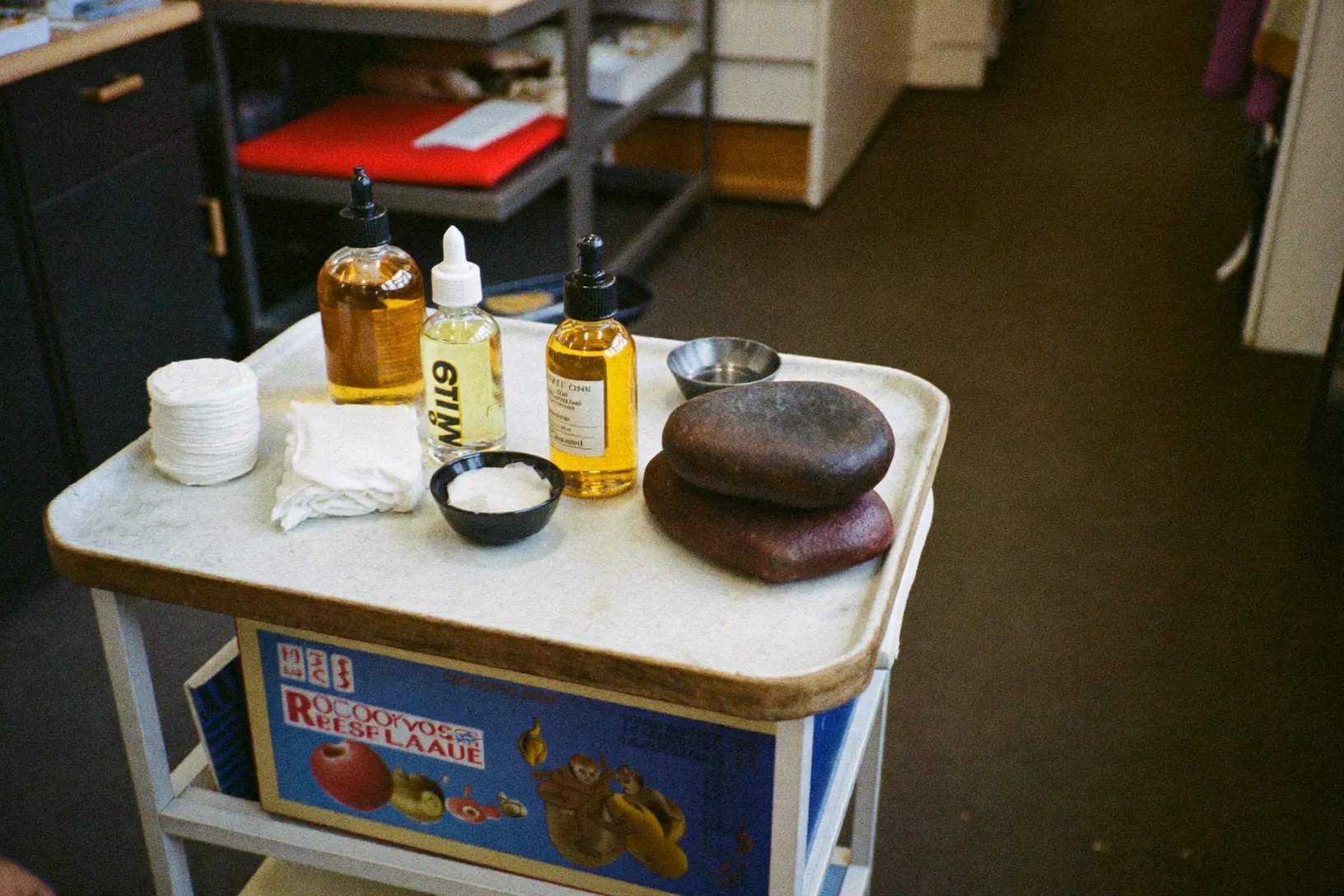 Close detail of massage oils and hot stones on the therapist's trolley