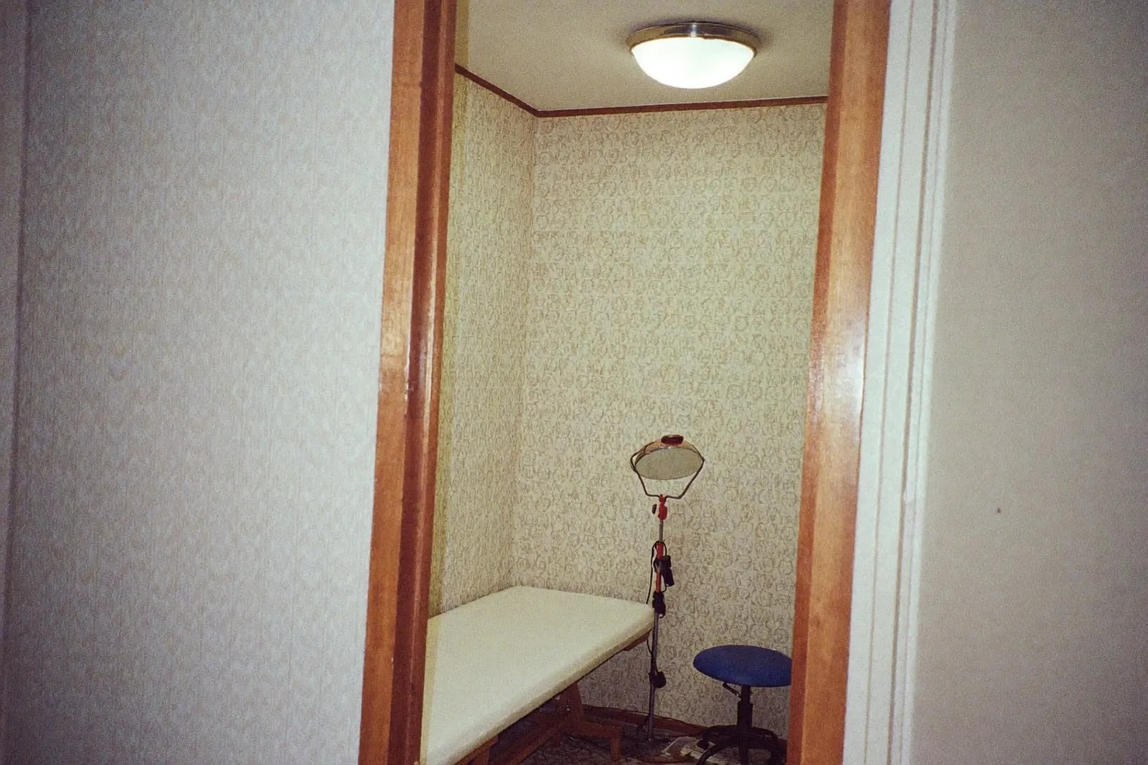 Second angle on the treatment room, looking through to the wallpapered alcove