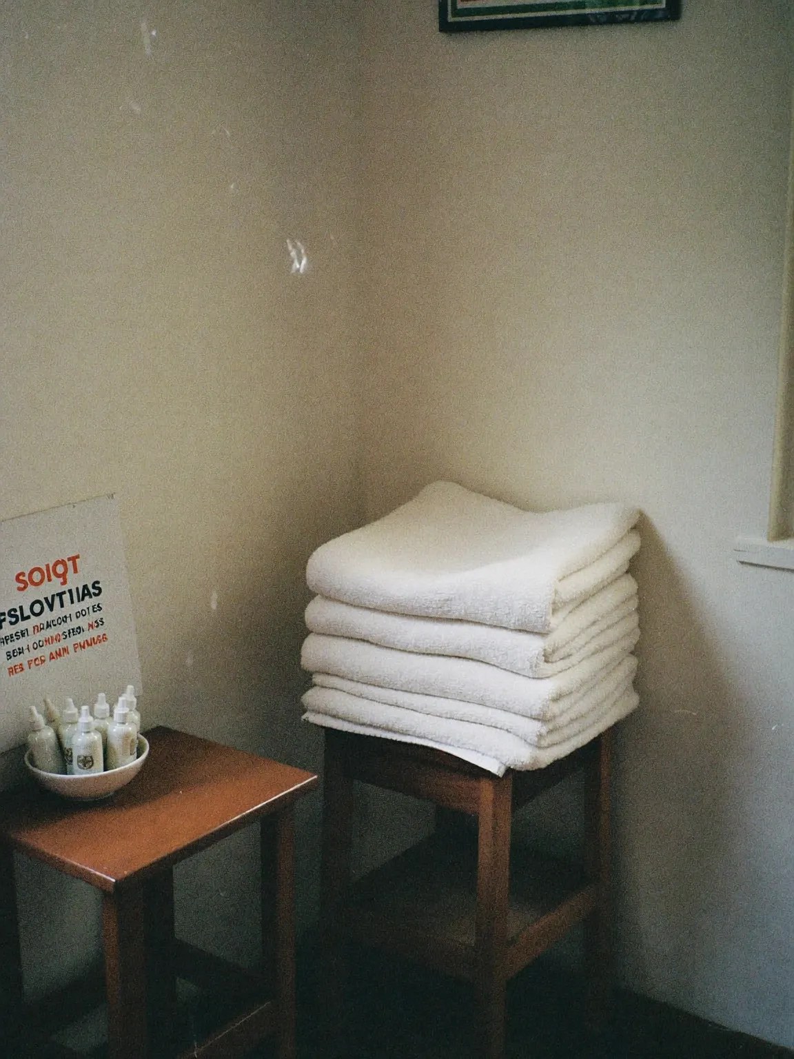 Folded towels and massage oils on a side table in the treatment room